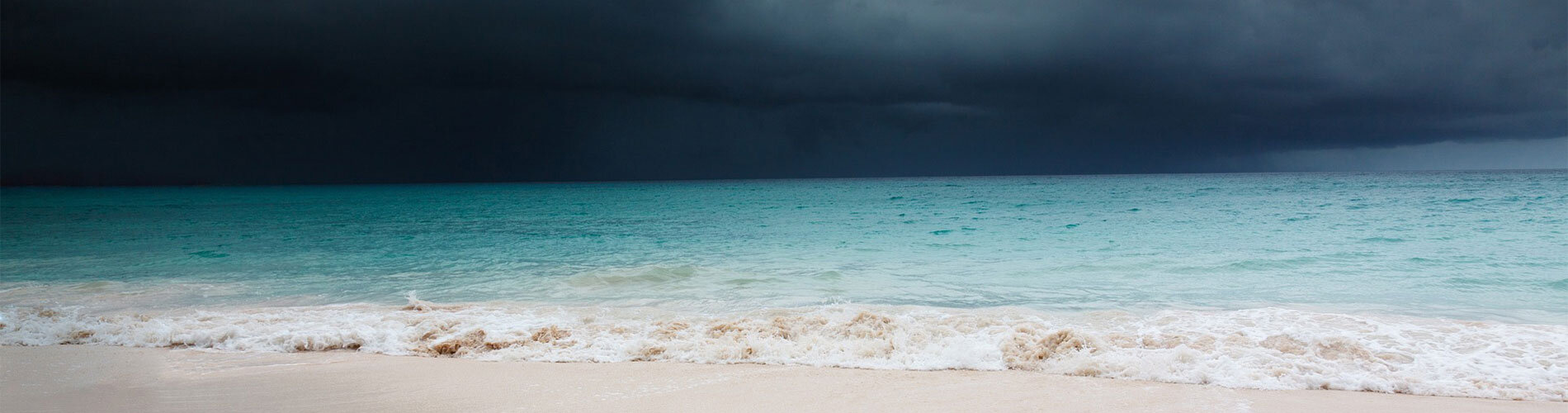 A dark cloud looms over a beach.